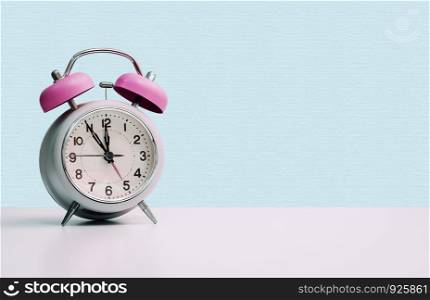 Retro styled white alarm clock, isolated and copy space, pink blue
