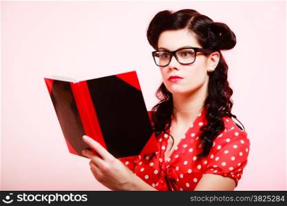 Retro. Stylish woman student or teacher in eyeglasses reading book on pink. Brunette girl in pinup style. Education.
