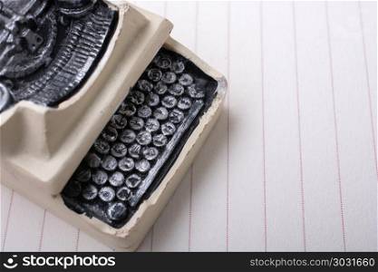 Retro syled tiny typewriter model on paper. Retro syled tiny typewriter model on a paper background