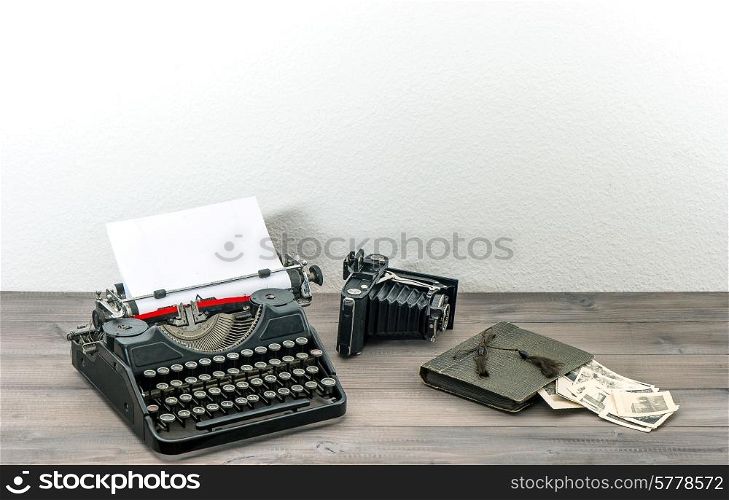 retro typewriter and vintage photo camera on wooden table. antique objects. collectibles