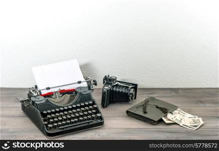retro typewriter and vintage photo camera on wooden table. antique objects. collectibles