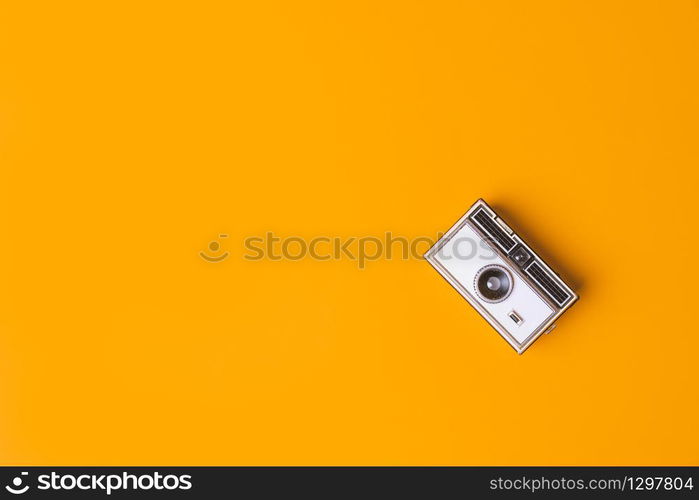 Retro vintage Photo Camera on a yellow Background