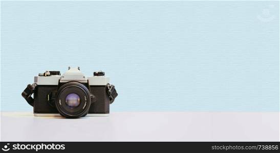 Retro vintage photography camera on blue colored background