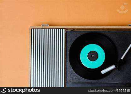 Retro vinyl player and turnable on a yellow background. Entertainment 70s. Listen to music. Top view.