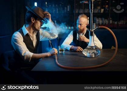 Retro well-dressed gangsters smoking hookah in bar. Serious handsome guys having business meeting while spending time at nightclub. Stylish gangsters smoking hookah in bar having business meeting