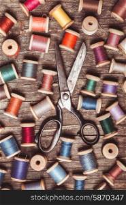 Retro wooden sewing spools with colourful threads and vintage scissors