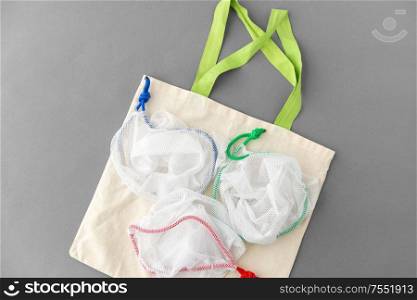 reuse and ecology concept - reusable bag and totes for food shopping on grey background. reusable bag and totes for food shopping