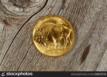 Reverse side of American Gold Buffalo coin, fine gold, on rustic wood.