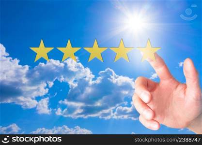 Review, increase rating or ranking, evaluation and classification concept. Businessman pointing on five yellow stars to increase rating of his company. Sky background