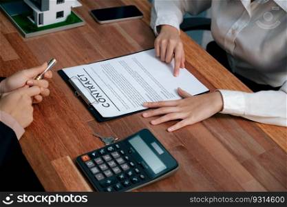 Reviewing house loan contract with agent. Analyzing financial documents and tax rates with calculator for ownership of property. Key signature for new home purchase and financing. Enthusiastic. Reviewing house loan contract with agent using calculator. Enthusiastic