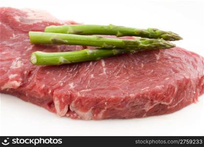 Rew beef and asparagus. photo of a raw beef with fresh asparagus