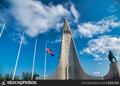 Reykjavik Cathedral on a sunny day with Iceland waving flag.