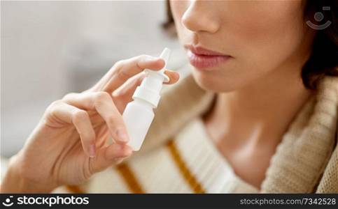 rhinitis, medicine and healthcare concept - close up of sick woman using nasal spray. close up of sick woman using nasal spray