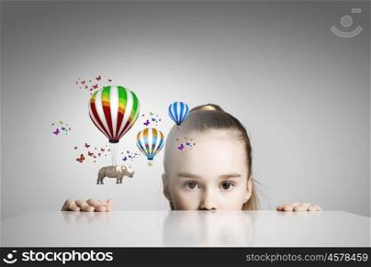 Rhino flying on balloons. Little cute girl looking from under the table