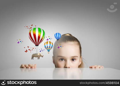 Rhino flying on balloons. Little cute girl looking from under the table