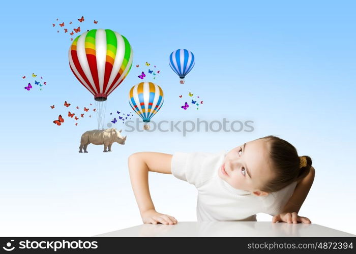 Rhino flying on balloons. Little cute girl looking from under the table