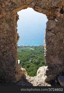 Rhodes island coast through wall opening of Monolithos castle. Greece.