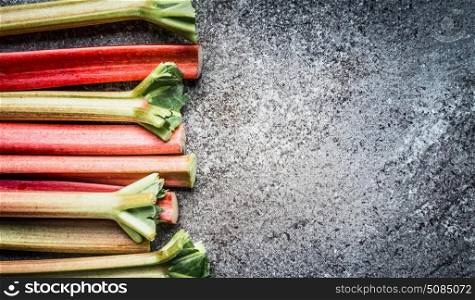 Rhubarb sticks on gray concrete background, top view. Superfood concept