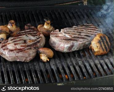 Rib eye steak and mushrooms on the grill , Seattle, Pacific Northwest
