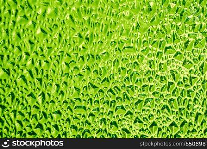 Ribbed decorative glass surface of green colour, background, texture