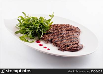 Ribeye steak with arugula on white plate