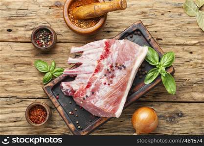 Ribs and pork chops on old wooden table. Raw pork on cutting board