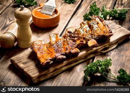 Ribs grill with beer and herbs. On a wooden table.. Ribs grill with beer and herbs.