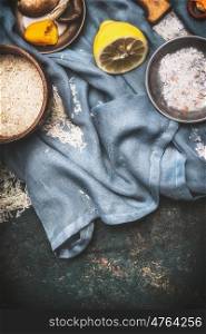 Rice and vegetarian cooking ingredients on dark rustic background with kitchen napkin, top view. Healthy food, Diet nutrition or Detox concept