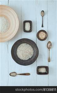 Rice of different varieties on wooden background.  