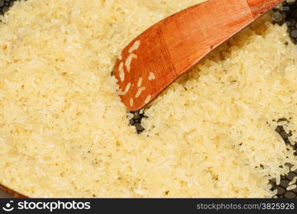 rice on frying pan, skillet, wood spoon