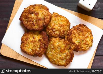 Rice patties or fritters made of cooked rice, carrot, onion, garlic and celery stalks, photographed overhead with natural light