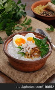 Rice porridge ginger congee with egg, chicken, crispy shallots and parsley