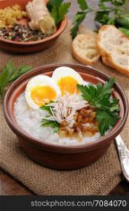 Rice porridge ginger congee with egg, chicken, crispy shallots and parsley