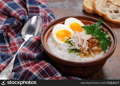 Rice porridge ginger congee with egg, chicken, crispy shallots and parsley