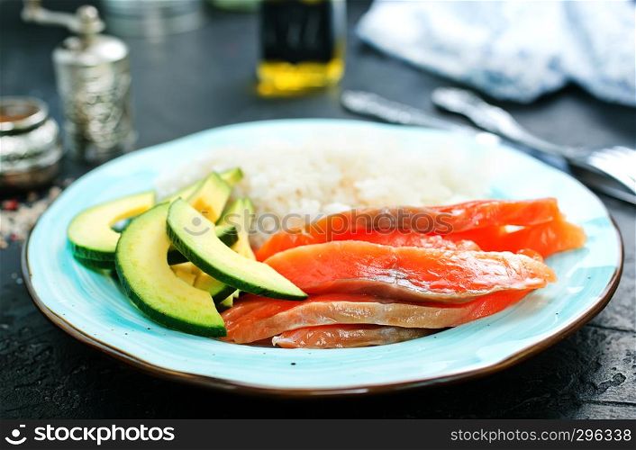 rice salmon avocado on plate on a table
