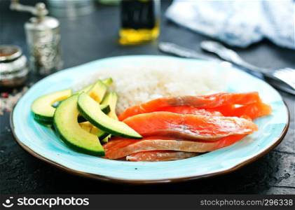 rice salmon avocado on plate on a table