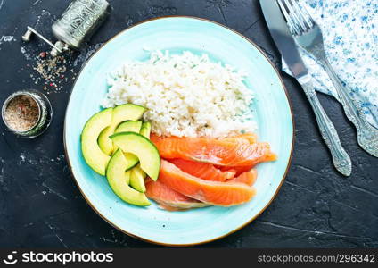 rice salmon avocado on plate on a table