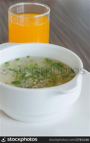 Rice soup with mince pork and vegetable served with orange juice. asian rice soup