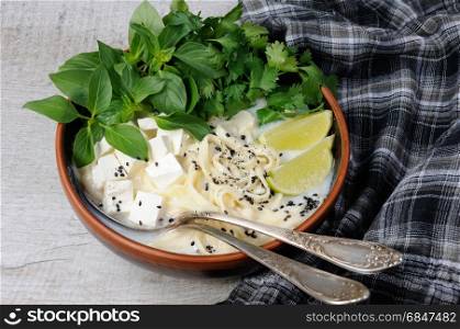 Rice soup with noodles and tofu flavored with lemon grass (basil), cilantro, sesame.