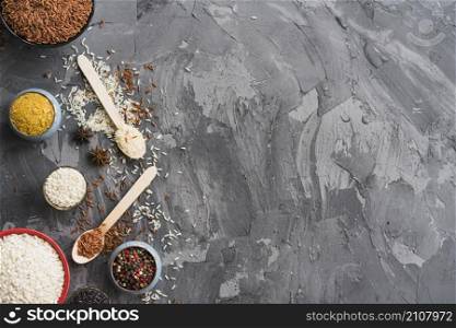 rice turmeric powder star anise peppercorn black weathered backdrop with space text