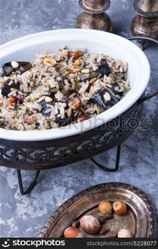 rice with mushrooms. traditional risotto from rice and mushrooms in an oval dish