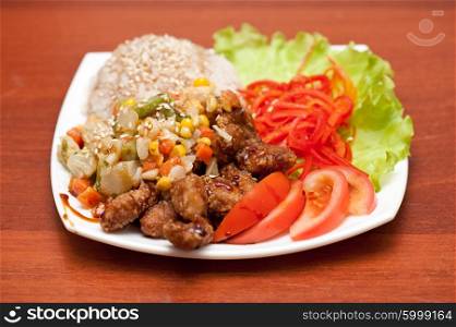 rice with roasted meat and vegetables. plate of chinese rice with roasted meat and vegetables