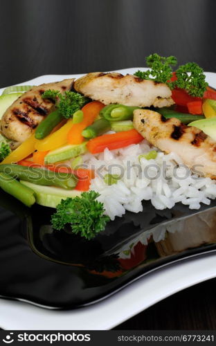 Rice with slices of chicken breast and vegetables