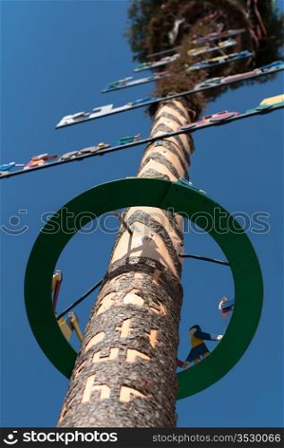 Richly decorated and engraved may pole on sky background