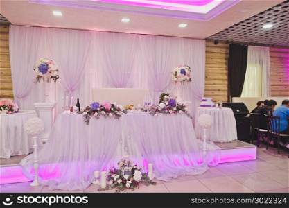 Richly decorated with flowers and fabrics hall for a wedding Banquet.. Gorgeously decorated main place in the room for the newlyweds 573.
