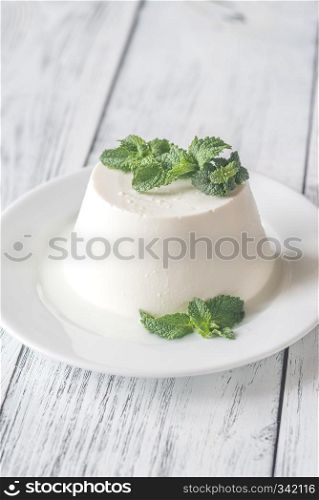 Ricotta decorated with fresh mint on the white plate