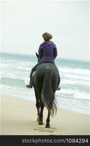 riding girl are training her horse on the beach