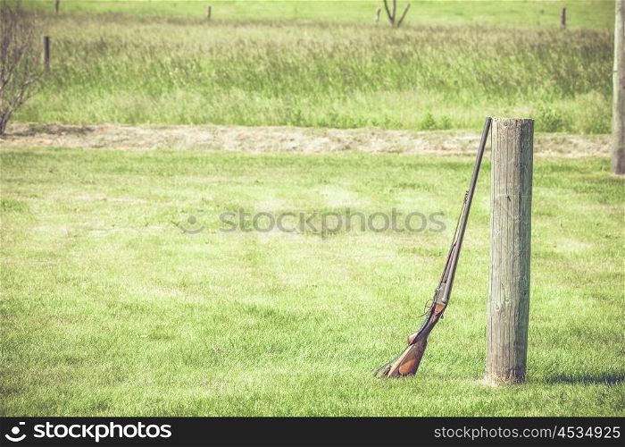 Rifle against a wooden log at an outdoor shooting range