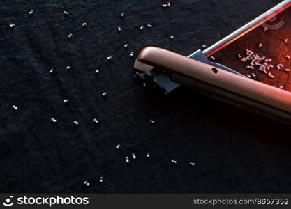 Rifle gun break in two with air pellets for hunting on cloth dark background with red light.. Rifle gun break in two with air pellets for hunting on cloth dark background with red light
