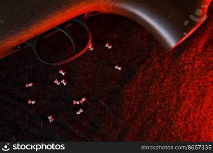 Rifle gun trigger with air pellets for hunting on cloth dark background with red light.. Rifle gun trigger with air pellets for hunting on cloth dark background with red light